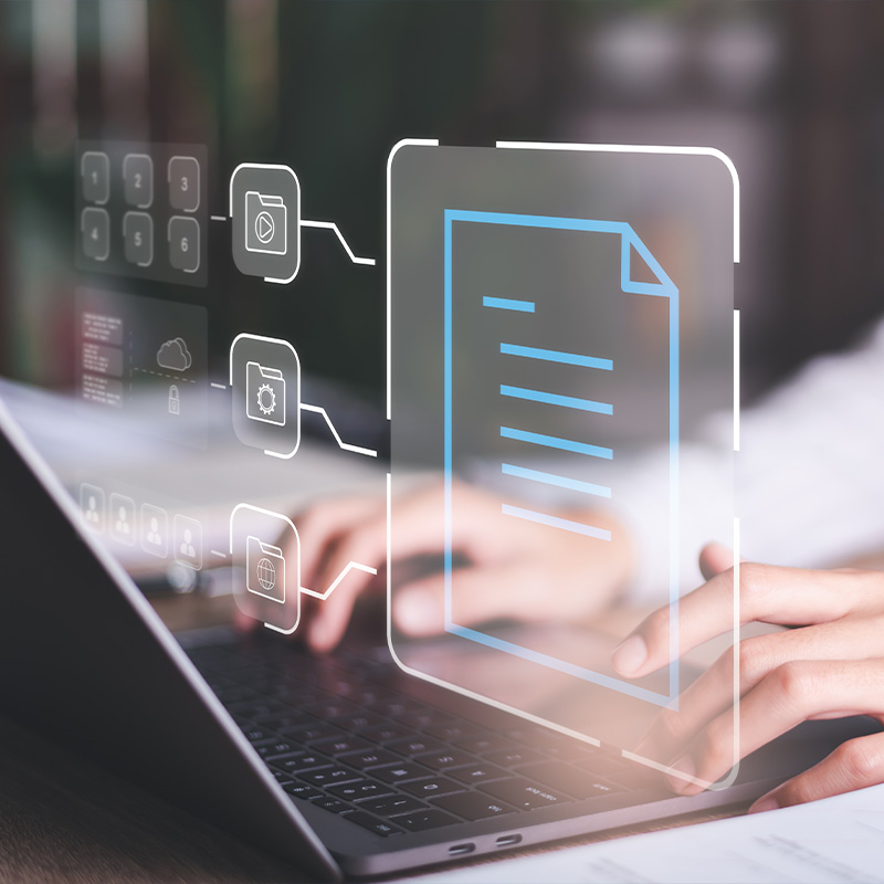 Hände tippen auf einer Laptop-Tastatur, während holografische Symbole für digitale Dokumente und Ordner erscheinen.